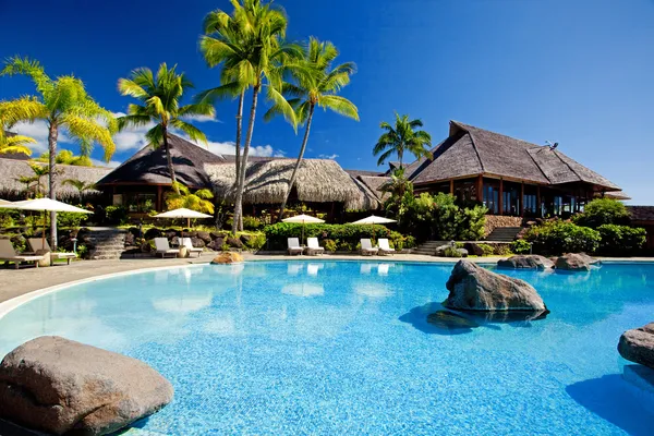 Palmen hängen über atemberaubendem Hotelpool — Stockfoto