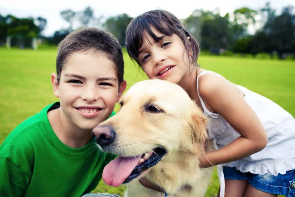 Młody chłopak i dziewczyna przytulanie złoty pies myśliwski — Zdjęcie stockowe