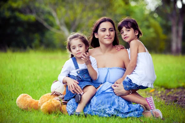 Mutter und zwei Töchter spielen im Gras — Stockfoto