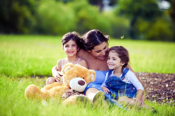母と二人の娘が草で遊ぶ — ストック写真