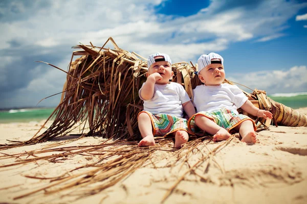 Ідентичні хлопчики-близнюки розслабляються на пляжі — стокове фото
