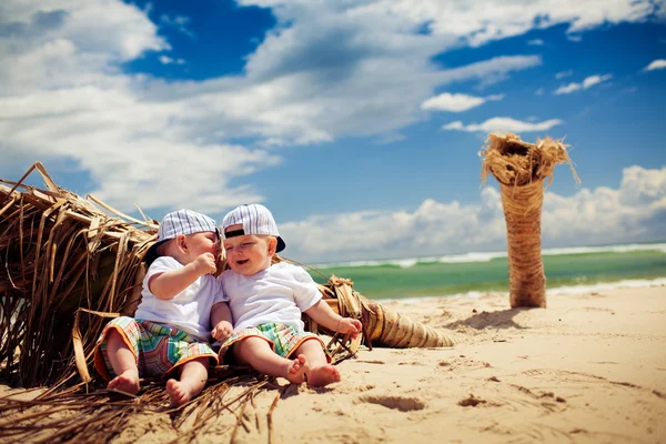 Ідентичні хлопчики-близнюки розслабляються на пляжі — стокове фото