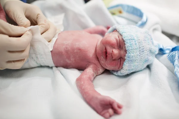 Bebê recém-nascido coberto de vérnix ficando fralda — Fotografia de Stock