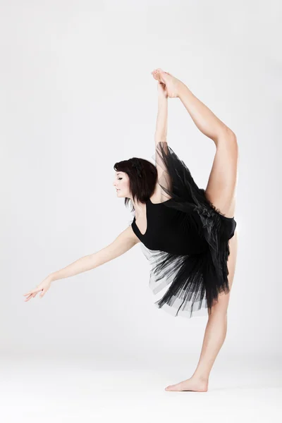 Bela bailarina feminina fazendo split contra branco — Fotografia de Stock