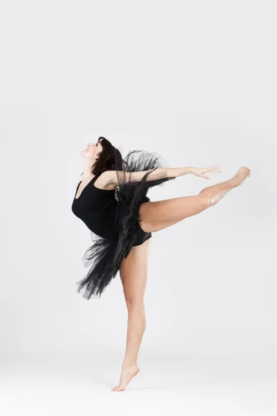 Bela bailarina fazendo split contra fundo branco — Fotografia de Stock