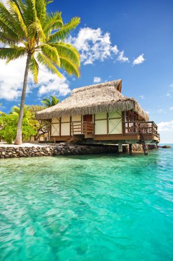 Over water bungalow with steps into amazing lagoon clipart