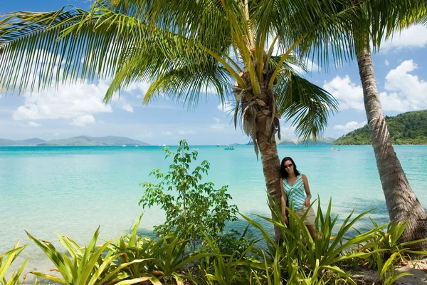 Kız bir tropik cennet bir palmiye ağacının altında — Stok fotoğraf