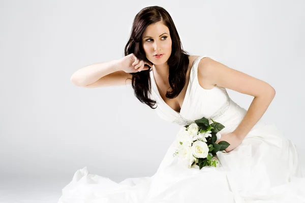 Gelukkig jonge bruid in trouwjurk met boeket — Stockfoto