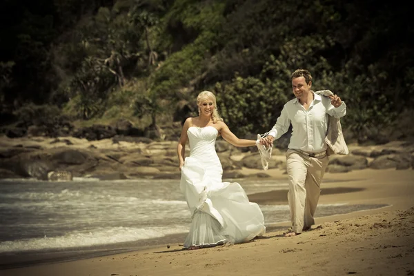 Passionné jeune couple marchant sur la plage — Photo