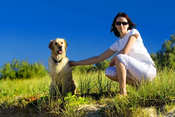 Молода жінка і собака сидить — стокове фото