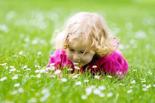 Klein meisje ruikende bloemen — Stockfoto