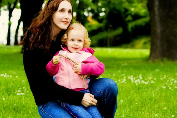 幸福的母亲和孩子坐在公园 — 图库照片