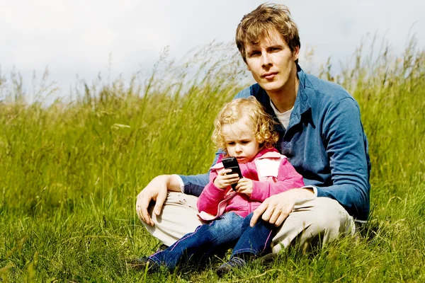 Pai e criança explorando telefone celular — Fotografia de Stock