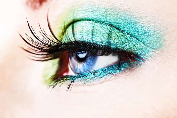 Detail eines blauen Auges mit grünem Lidschatten — Stockfoto