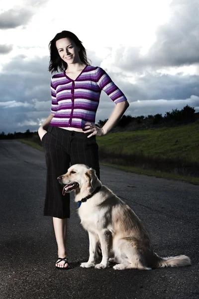 年轻女子和一条狗的道路上 — 图库照片