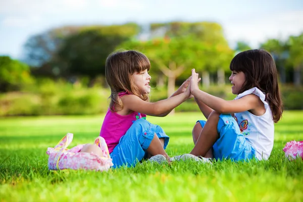 Twee Jonge Meisjes Zitten Het Groene Gras Glimlachen — Stockfoto