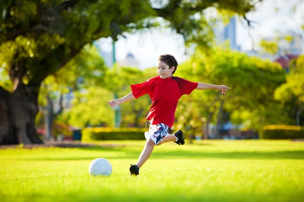 Молодой Возбужденный Мальчик Пинает Мяч Траве Улице — стоковое фото