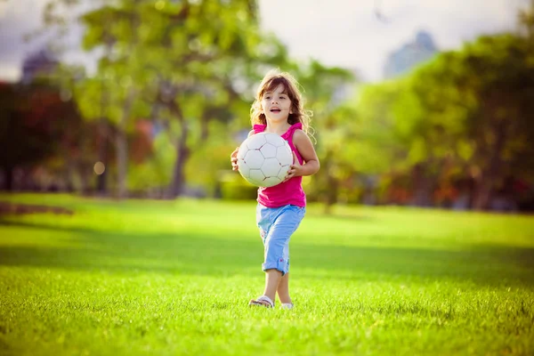 Молодая девушка в парке держит белый мяч — стоковое фото