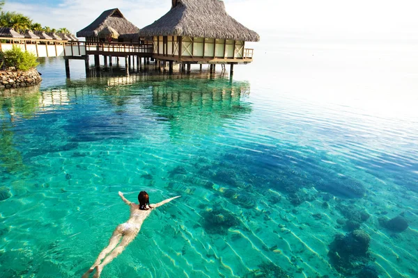 年轻女子在珊瑚环礁湖中游泳 — 图库照片