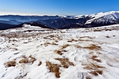 dağ manzarası dışında ön planda kar altında çim