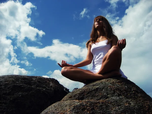 Дівчина медитує на гірському схилі Стокова Картинка