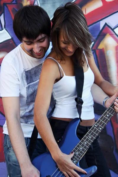 Young guy teach a girl to play the guitar — Stock Photo, Image