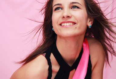 Beautiful young smiling girl on a pink background clipart