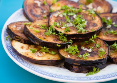 Fried aubergines (eggplant) with freshly grated garlick and pars clipart