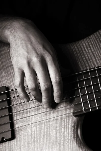 Playing six-string electric bass guitar; fingerpicking, right hand; toned m — Stock Photo, Image