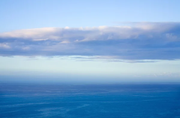 Oceano com camada de nuvens iluminadas por subconjuntos — Fotografia de Stock