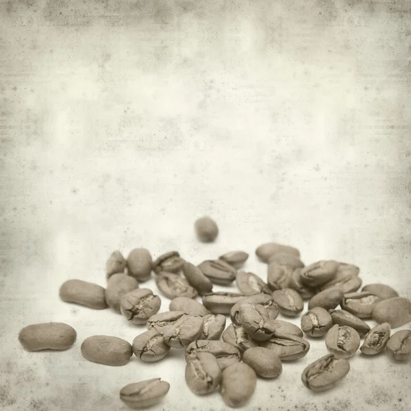 散乱のコーヒー豆と織り目加工の古い紙の背景 — ストック写真