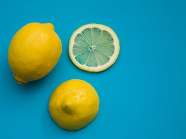 Kesme limon - bütün limon; yarısı; ve parlak mavi plastik dilimleri uyur