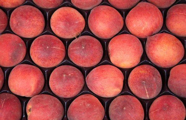 Красные спелые персики для продажи на рынке ; — стоковое фото