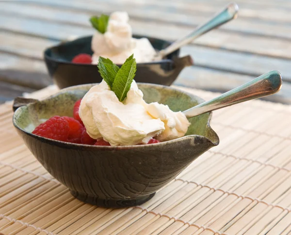 Raspberry segar disajikan dengan krim kocok dan setangkai mi segar — Stok Foto
