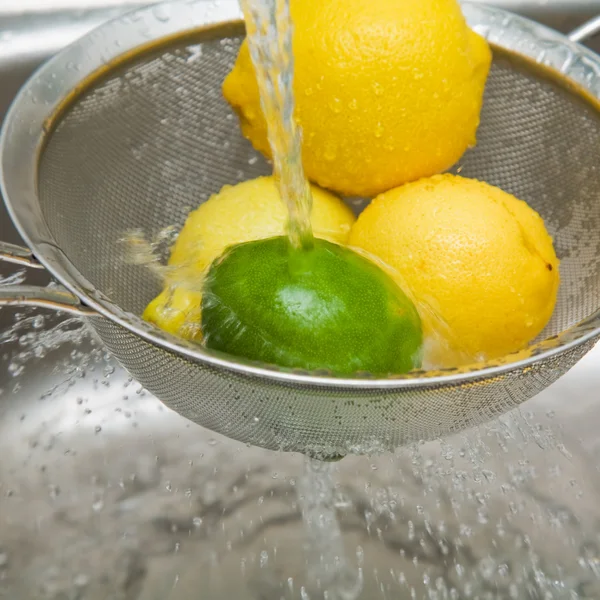 stock image Washing lemons and lime in a sieve