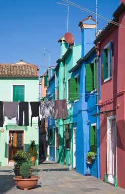 Burano island in lagoon of Venice; famous brightly-colored houses clipart