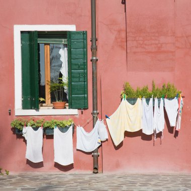 Burano island in lagoon of Venice; brightly-colored house; washing clipart