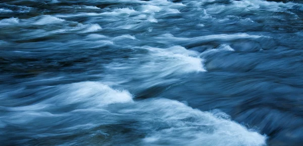 Fast-flowing water background, long exposure — Stock Photo, Image