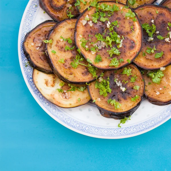 Жареные баклажаны со свежетертым чесноком и петрушкой — стоковое фото