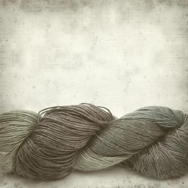 Textured old paper background with hand-dyed yarn skein — Stock Photo, Image