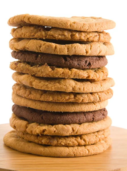 Alta pilha de diferentes tipos de cookies na superfície de madeira, isolado em wh — Fotografia de Stock