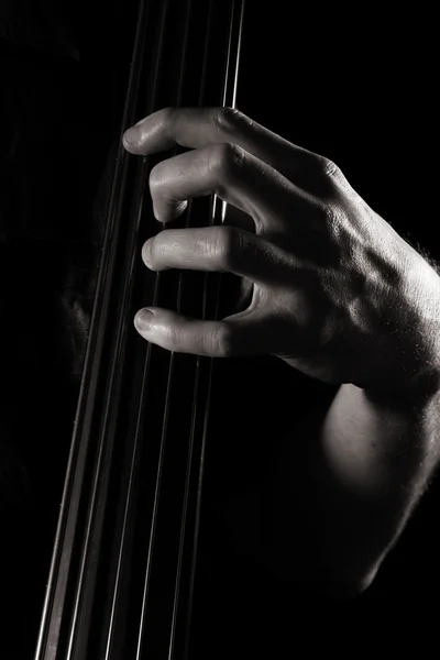 Male hand on the neck of electric double bass; toned monochrome image — Stock Photo, Image