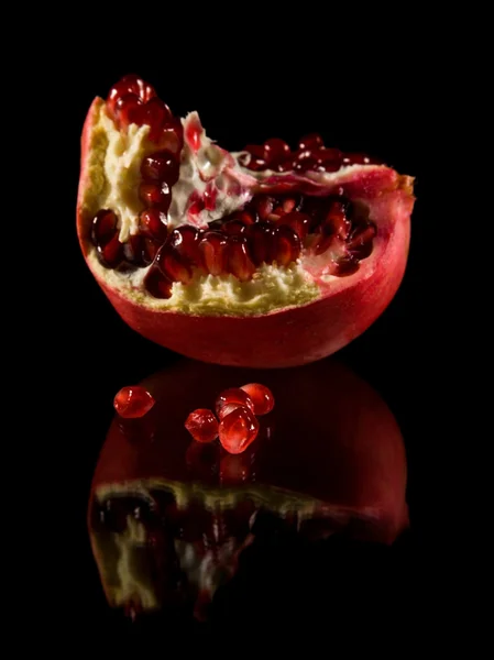 석류; 깨진된 과일 검은 반사 표면에 절연; — 스톡 사진
