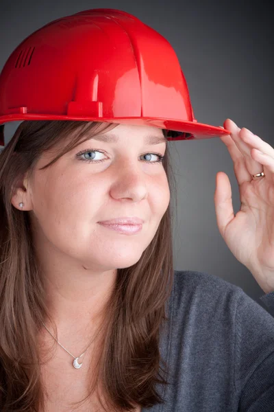 Portrait of young architect wearing red hardhat — Zdjęcie stockowe