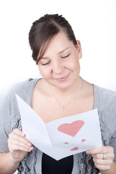 Portrait de jeune femme heureuse attrayante, lecture de la carte de Saint-Valentin — Photo