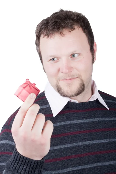Young man holding valentine gift in his hand. He is giving it so — Stock Photo, Image