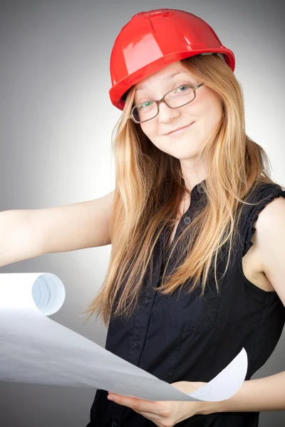 Young woman in helmet with blueprint — Stock Photo, Image