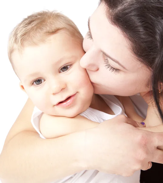 Ευτυχής νεαρή μητέρα φιλιά ένα μωρό Royalty Free Εικόνες Αρχείου