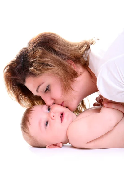 Szczęśliwa młoda matka całuje dziecko — Zdjęcie stockowe