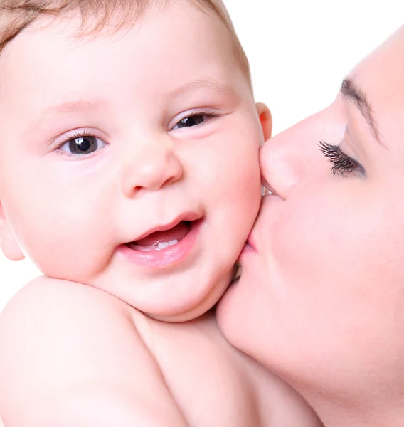 Glückliche junge Mutter küsst ein Baby — Stockfoto